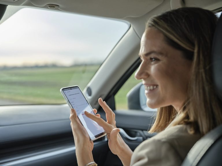Donna in auto che controlla la casa con l'app VELUX