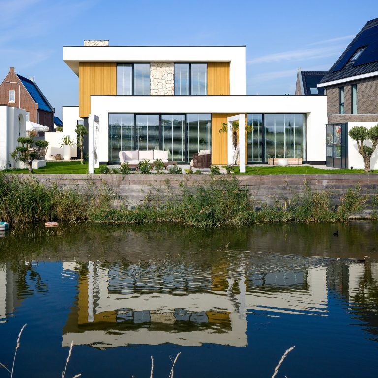 Casa moderna con vetrate in alluminio riflessa nell'acqua (FIN-Project Nova-line 78/88)