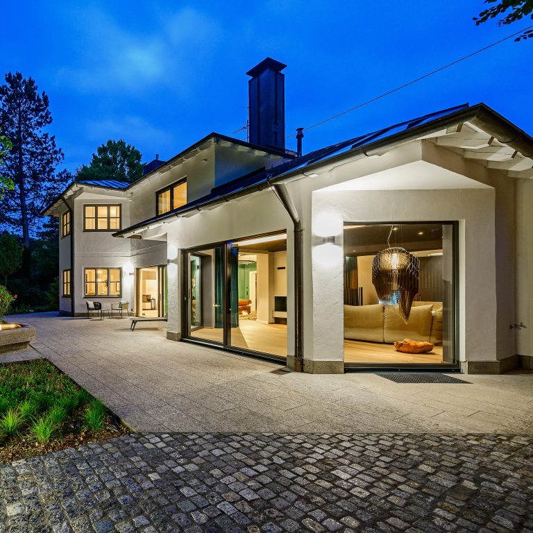 Villa illuminata la sera con grandi vetrate in alluminio (FIN-Project, FIN-Slide Slim-line Cristal)