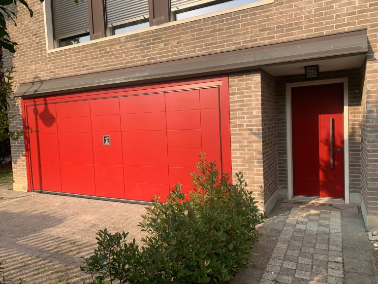 Basculante Secur laccata rossa a pannelli abbinata al portoncino rosso, casa in mattoni