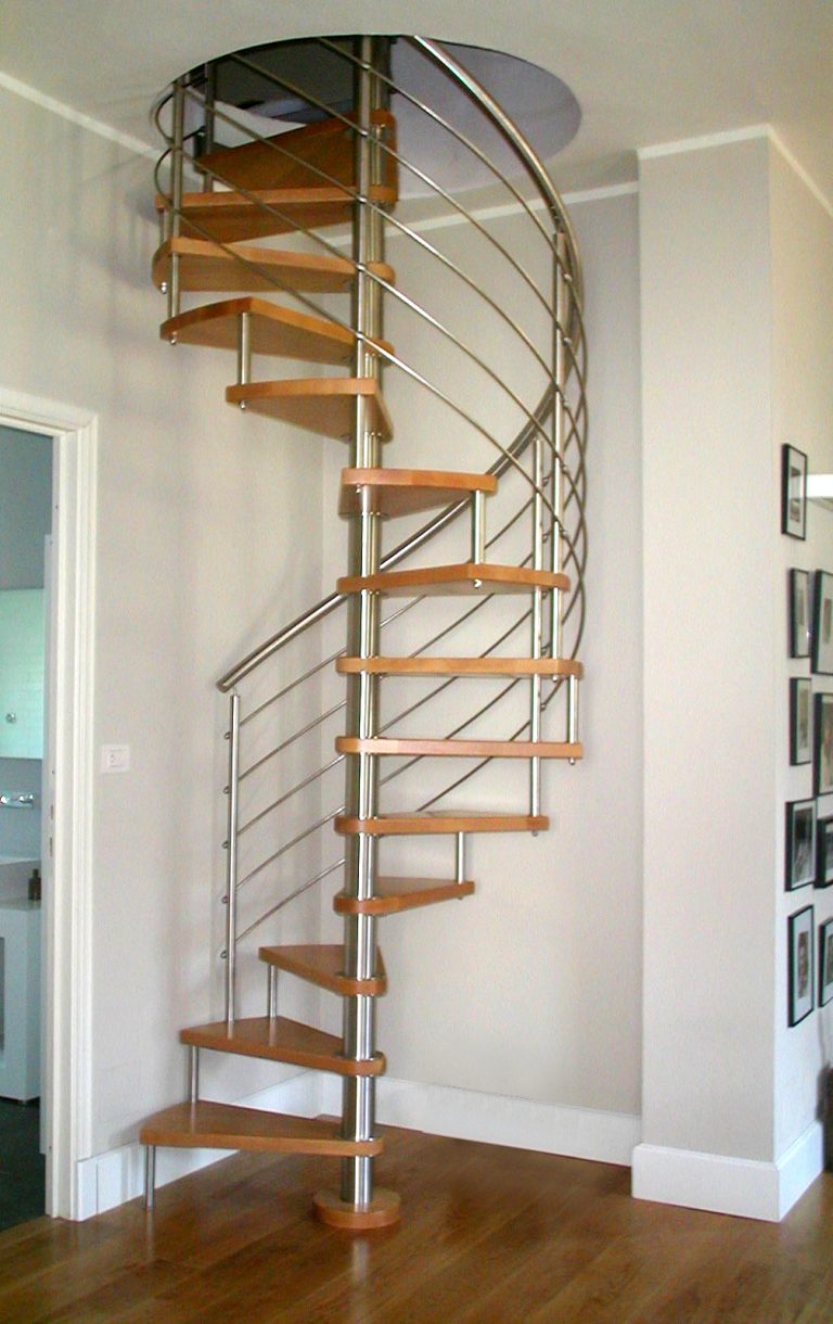 Scala a chiocciola in acciaio inox con gradini in legno in un vano di casa, verticale