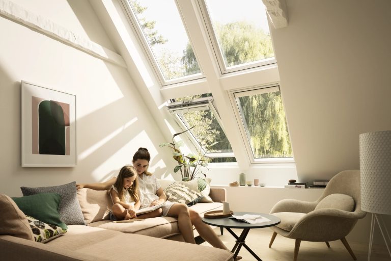Famiglia sul divano sotto finestre per tetti combinate