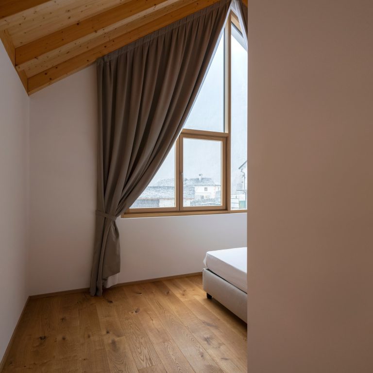 Camera in mansarda con finestra dal telaio in legno (FIN-Project alluminio-legno)