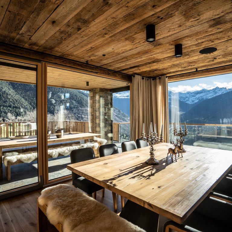 Sala da pranzo in chalet con soffitto in legno e vetrate sulle montagne (FIN-Project Slim-line 78/95 alluminio-legno)