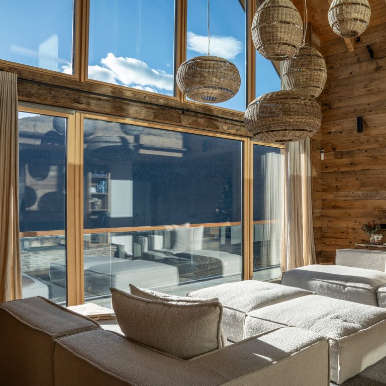 Soggiorno di chalet con grandi vetrate e rivestimenti in legno (FIN-Project)
