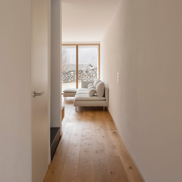 Corridoio con parquet e portafinestra in legno in fondo (FIN-Project alluminio-legno)