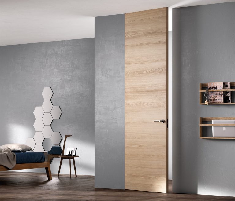 Porta filomuro Exit Zero a tutta altezza in rovere chiaro su parete grigia