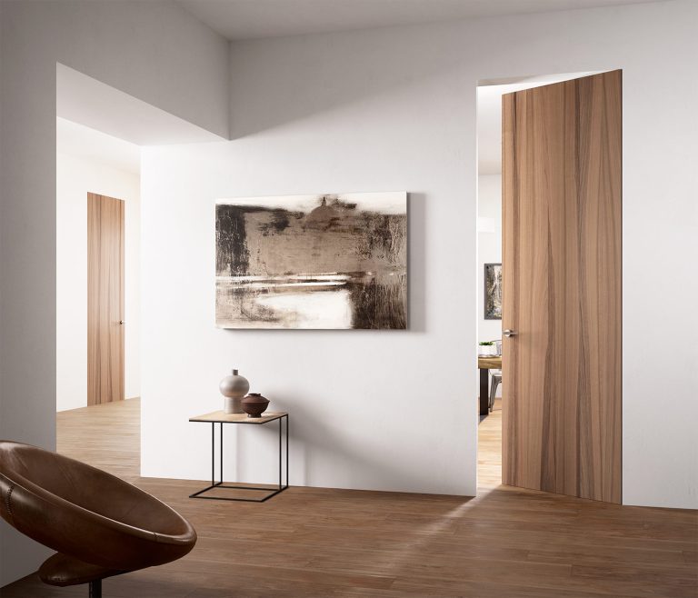 Porta filomuro Exitlyne Zero in noce aperta, soggiorno bianco con quadro