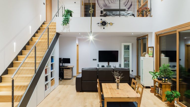 Soggiorno a doppia altezza con serramenti alluminio-PVC, interno effetto legno