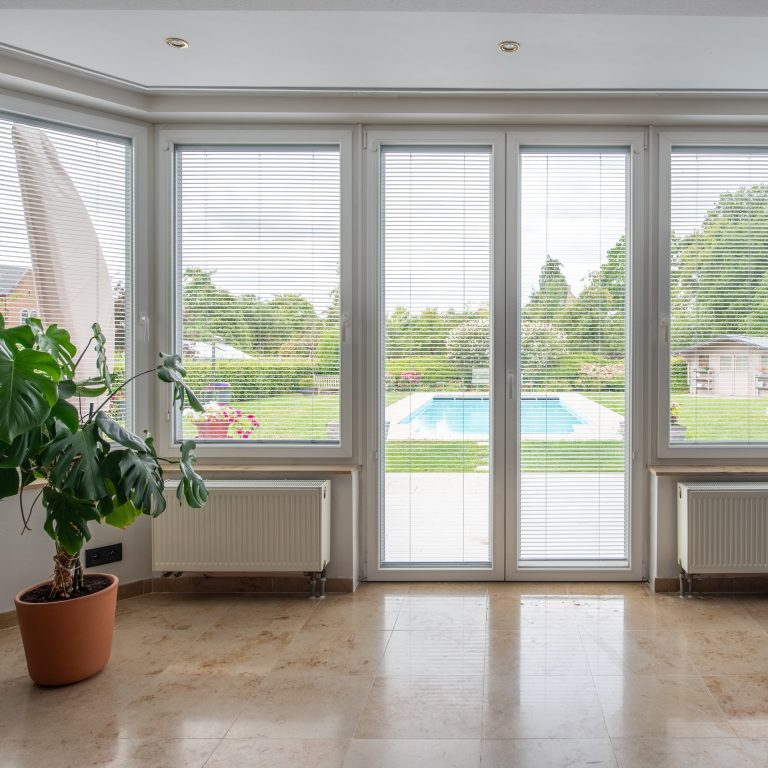 Bovindo con portefinestre in PVC bianco e vista piscina (FIN-Window Slim-line Twin PVC-PVC)