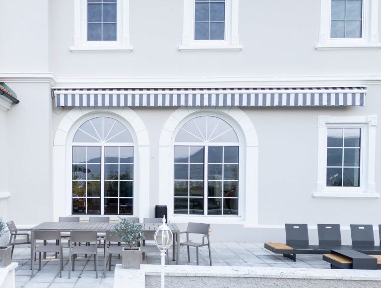 Facciata di villa con finestre ad arco in PVC bianco sulla terrazza (FIN-Window Nova-line PVC-PVC)