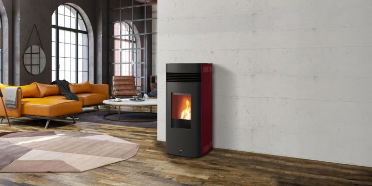 Stufa a pellet Superior Cleope bordeaux in loft con vetrate ad arco e divano giallo (marchio Superior, gruppo Piazzetta)